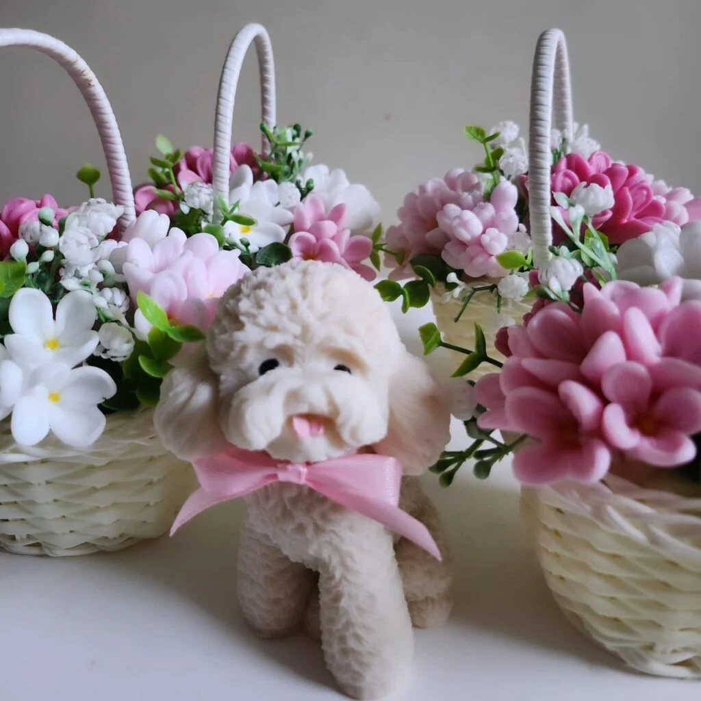 Cagnolino bianco in sapone profumato con fiocco rosa inserito in una composizione floreale artigianale